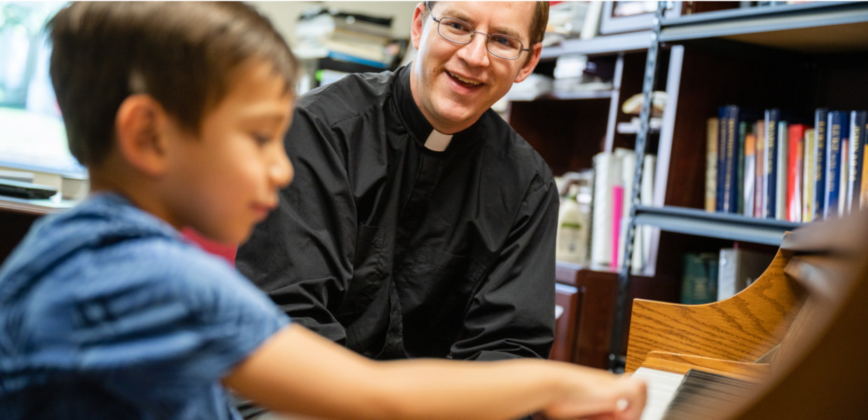 Conservatory faculty member teaching a young student at the piano.